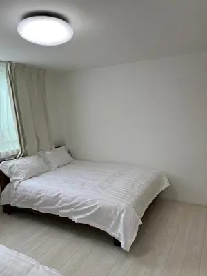 a bedroom with a large bed with a white comforter at Tokyo Link House Halona-Direct to Shinjuku, Shibuya, Ginza in Tokyo