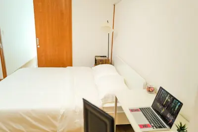 a bedroom with a bed and a laptop on a table at \u4e1c\u4eac\u5854\u9644\u8fd13\u5e8a\u516c\u5bd3 in Tokyo
