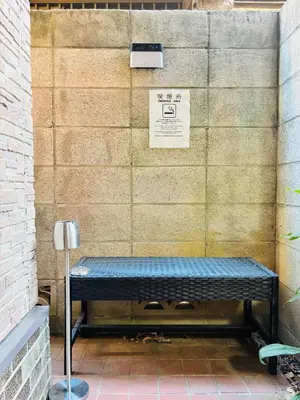 a bench sitting in front of a wall at \u967d\u3060\u307e\u308a\u306e\u3046\u305f\u305f\u306d\u3053\u8358 in Tokyo