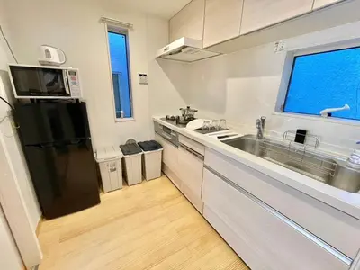 a kitchen with a black refrigerator and a sink at \u5317\u65b0\u5bbf\u306e\u4e00\u8ed2\u5bb6\u8cb8\u5207 3\u5bdd\u5ba45\u30d9\u30c3\u30c9 \u5927\u4e45\u4fdd\u99c5\u5f92\u6b6912\u5206 \u65b0\u5bbf\u6c60\u888b\u539f\u5bbf\u6e0b\u8c37\u30a8\u30ea\u30a2 in Tokyo