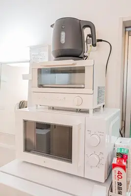 a toaster oven sitting on top of other appliances at 8 min walk to JR Chuo Sobu Line Station Ground Floor Room 13 min to Tokyo Direct Train to Asakusa Shinjuku Ueno Akihabara 22sqm in Tokyo