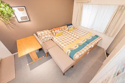 a bedroom with a bed and a couch and a table at 8 min walk to JR Chuo Sobu Line Station Ground Floor Room 13 min to Tokyo Direct Train to Asakusa Shinjuku Ueno Akihabara 22sqm in Tokyo