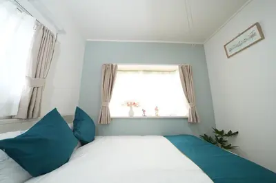 a bedroom with a bed with blue pillows and a window at \u5927\u4eba\u6c17\u30a8\u30ea\u30a2\u65b0\u5bbf\u307e\u3067\u96fb\u8eca4\u5206 Jr\u6771\u4e2d\u91ce\u99c5\u5f92\u6b696\u5206 \u5927\u4e45\u4fdd\u99c5\u5f92\u6b6910\u5206 \u6700\u59275\u540d\u69d8 \u304a\u8377\u7269\u9810\u53ef in Tokyo