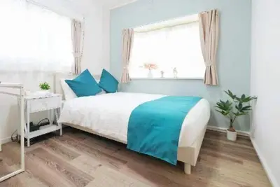a bedroom with a bed with blue sheets and a window at \u5927\u4eba\u6c17\u30a8\u30ea\u30a2\u65b0\u5bbf\u307e\u3067\u96fb\u8eca4\u5206 Jr\u6771\u4e2d\u91ce\u99c5\u5f92\u6b696\u5206 \u5927\u4e45\u4fdd\u99c5\u5f92\u6b6910\u5206 \u6700\u59275\u540d\u69d8 \u304a\u8377\u7269\u9810\u53ef in Tokyo