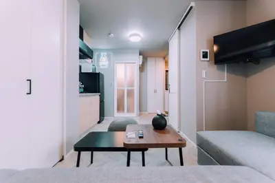 a living room with a table and a couch at Showa Bloom Cozy Stay Near Shinjuku in Tokyo