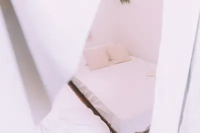 a small bed in a room with white walls at Showa Bloom Stay Near Shinjuku & Yoyogi in Tokyo