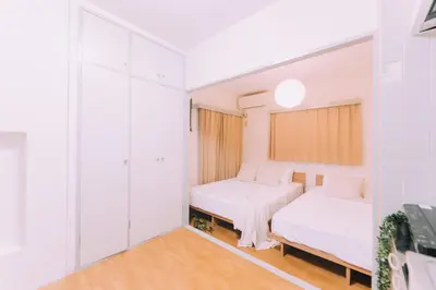 two beds in a room with white walls at Showa Bloom Stay Near Shinjuku & Yoyogi in Tokyo