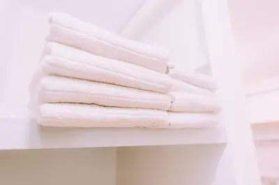 a stack of towels on a shelf in a bathroom at Showa Bloom Stay Near Shinjuku & Yoyogi in Tokyo