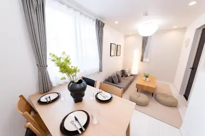 a living room with a table and a couch at \u6771\u5411\u5cf6House in Tokyo