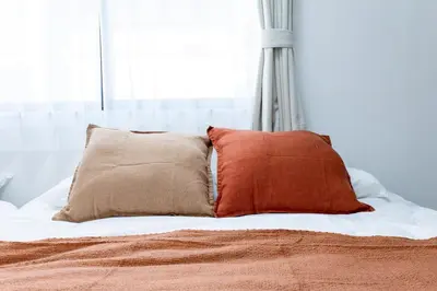 a bed with two pillows on top of it at \u6771\u5411\u5cf6House in Tokyo