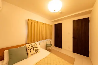 a bedroom with a bed and a window at \u6771\u5411\u5cf6House in Tokyo