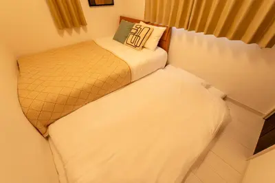 two beds in a small room with at \u6771\u5411\u5cf6House in Tokyo