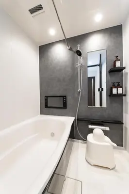 a white bathroom with a tub and a mirror at \u6771\u5411\u5cf6House in Tokyo