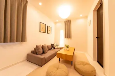 a living room with a couch and a table at \u6771\u5411\u5cf6House in Tokyo