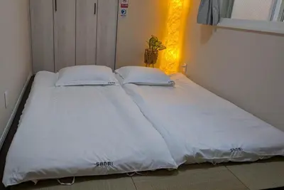 a bed with white sheets and pillows in a room at MOMO Garden in Tokyo