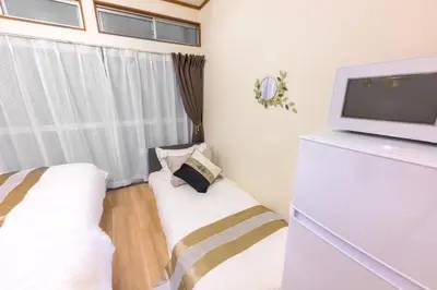 a small room with a bed and a tv at \u65b0\u5bbf\u99c54\u52062\u99c5\u304b\u3089\u5f92\u6b6910\u5206 \u6700\u59273\u540d \u9ad8\u901fWiFi 1\u968e\u306e\u307e\u308b\u307e\u308b\u8cb8\u5207\u90e8\u5c4b in Tokyo
