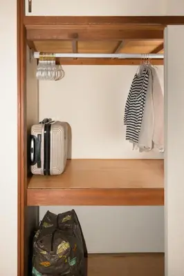 a closet with a wooden shelf with a suitcase at \u65b0\u5bbf\u99c54\u52062\u99c5\u304b\u3089\u5f92\u6b6910\u5206 \u6700\u59273\u540d \u9ad8\u901fWiFi 1\u968e\u306e\u307e\u308b\u307e\u308b\u8cb8\u5207\u90e8\u5c4b in Tokyo