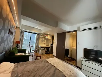 a bedroom with a bed and a television and a living room at Tokyo Asakusa's Local Side in Wada
