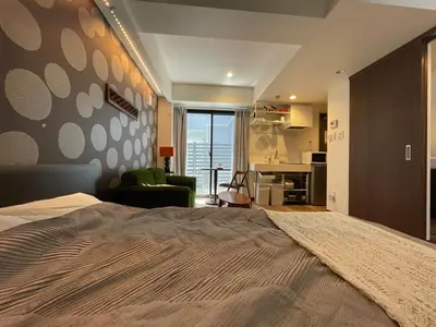 a bedroom with a large bed and a living room at Tokyo Asakusa's Local Side in Wada