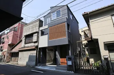 a black and white building on a city street at Urbané Villa -Kaname House- in Tokyo