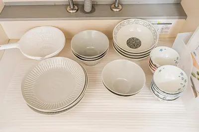a bunch of plates and bowls sitting on a drawer at self-check in CASA shinjuku in Tokyo