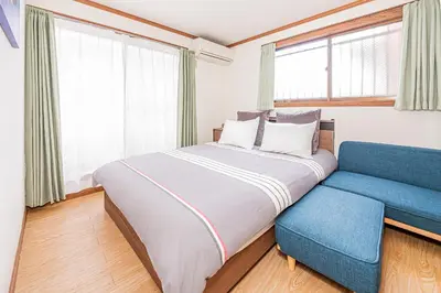 a bedroom with a large bed and a blue couch at self-check in CASA shinjuku in Tokyo