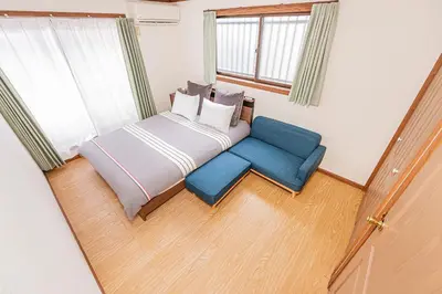 a bedroom with a bed and a blue chair at self-check in CASA shinjuku in Tokyo