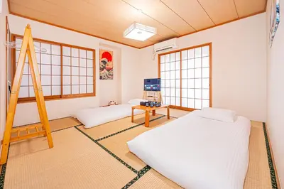 a bedroom with two beds and a ladder and windows at self-check in CASA shinjuku in Tokyo