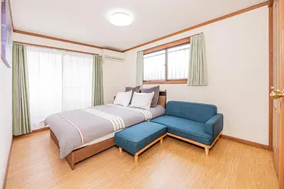 a bedroom with a bed and a blue chair at self-check in CASA shinjuku in Tokyo