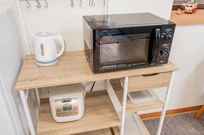 a microwave oven sitting on a table with a coffee maker at self-check in CASA shinjuku in Tokyo