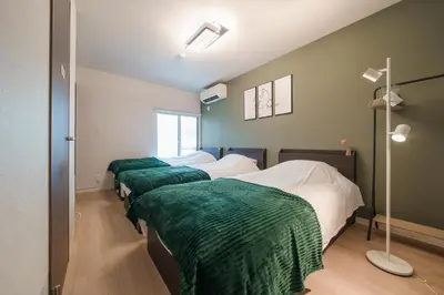 a row of four beds in a room at Takasa House in Tokyo