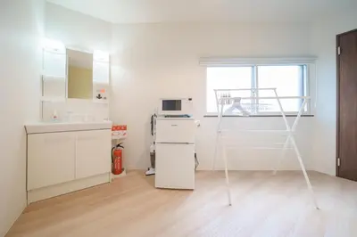 a white kitchen with a ladder in a room at Takasa House in Tokyo