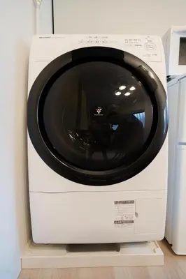 a white washing machine sitting on a shelf at Takasa House in Tokyo