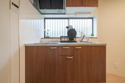 a kitchen with wooden cabinets and a sink and a window at Takasa House in Tokyo