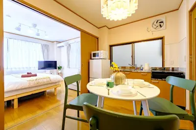 a room with a table and chairs and a kitchen at M-Base Ryogoku Tokyo - Easy Access to Asakusa & Skytree - Steps to Sumo Stadium & Museum in Tokyo