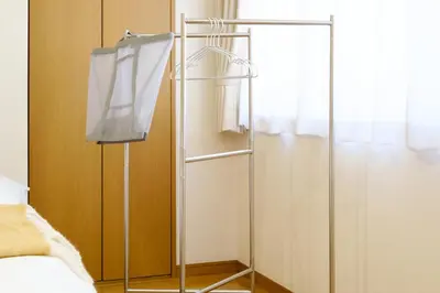 a towel rack next to a bed in a room at M-Base Ryogoku Tokyo - Easy Access to Asakusa & Skytree - Steps to Sumo Stadium & Museum in Tokyo