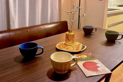 a wooden table with two cups and a vase on it at SAYO Serene Traditional Home, 8-min walk to JR Yamanote Line in Tokyo