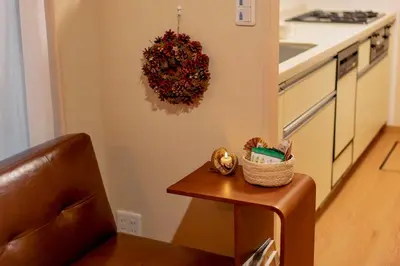 a small table in a kitchen with a wreath on the wall at SAYO Serene Traditional Home, 8-min walk to JR Yamanote Line in Tokyo