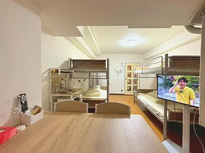a room with two bunk beds and a flat screen tv at Shibuya Lions in Tokyo