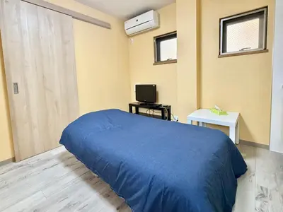 a bedroom with a blue bed and a television at Tokyo Stay Itabashi #102 in Tokyo