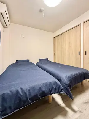 a bedroom with a bed with a blue comforter at Tokyo Stay Itabashi #102 in Tokyo