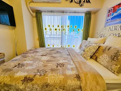 a bedroom with a large bed and a window at Cozy room Airport and Disneyland direct bus in Tokyo
