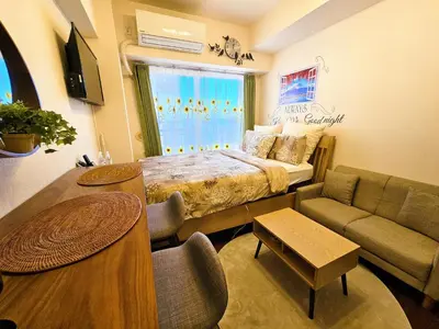 a bedroom with a bed and a couch and a table at Cozy room Airport and Disneyland direct bus in Tokyo