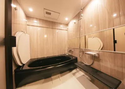 a bathroom with a black tub and a toilet at A-LifePENTHOUSE in Tokyo