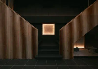 a staircase in a room with a light on the wall at A-LifePENTHOUSE in Tokyo