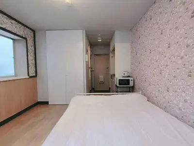 a bedroom with a large bed with a pink wall at Shin-Ookubo station 8 min walk#Shinjuku#speed wifi#\u65b0\u5bbf\u5927\u4e45\u4fdd\u97e9\u56fd\u6b65\u884c\u8857#JR\u65b0\u5927\u4e45\u4fdd\u7ad9\u6b65\u884c8\u5206\u949f#\u9633\u5149\u6e29\u99a8\u516c\u5bd3#\u9ad8\u901f\u65e0\u9650\u5236\u7f51\u7edclucky in Tokyo