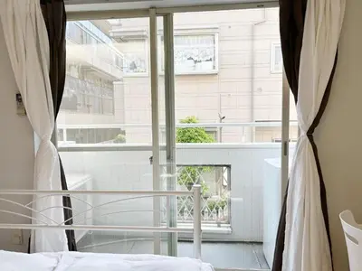 a bedroom with a bed and a large window at Shin-Ookubo station 8 min walk#Shinjuku#speed wifi#\u65b0\u5bbf\u5927\u4e45\u4fdd\u97e9\u56fd\u6b65\u884c\u8857#JR\u65b0\u5927\u4e45\u4fdd\u7ad9\u6b65\u884c8\u5206\u949f#\u9633\u5149\u6e29\u99a8\u516c\u5bd3#\u9ad8\u901f\u65e0\u9650\u5236\u7f51\u7edclucky in Tokyo