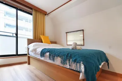 a bedroom with a bed and a large window at Tokyo Tsuruga Villa\u30fc\u6771\u4eac\u96c5\u9db4 in Tokyo