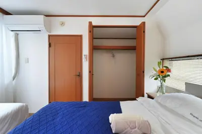 a bedroom with a blue bed and a door at Tokyo Tsuruga Villa\u30fc\u6771\u4eac\u96c5\u9db4 in Tokyo