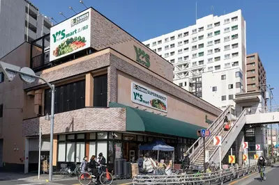 a building with people sitting outside of it on a street at \u6625\u660eHouse in Tokyo